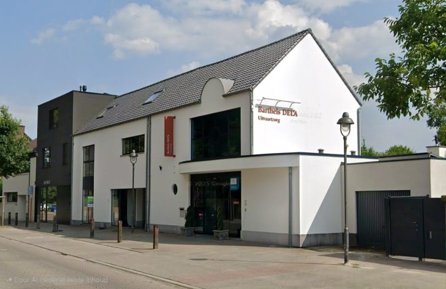 Aanzicht buitengevel met wit gekaleide muur waarop Uitvaartzorg Barthels DELA staat